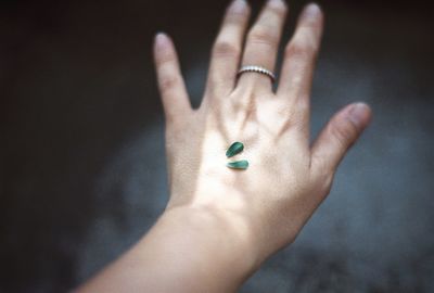 Cropped image of hand holding face over white background