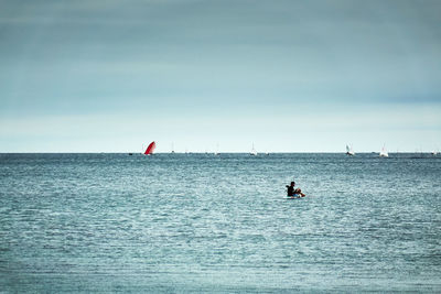 Man sailing on sea against sky