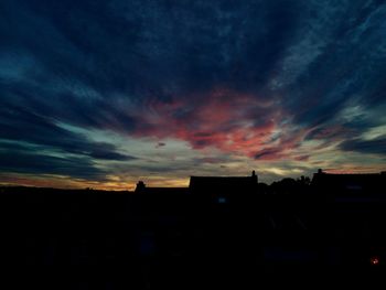 Silhouette buildings against sky at sunset