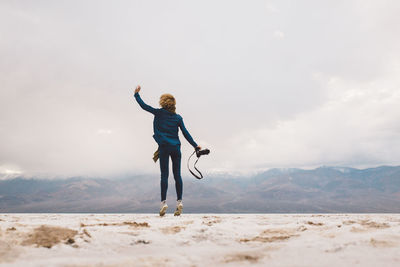 Full length of woman standing on mountain against sky