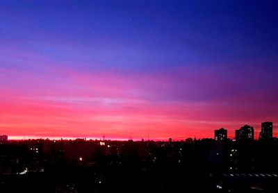 Silhouette buildings against sky at sunset