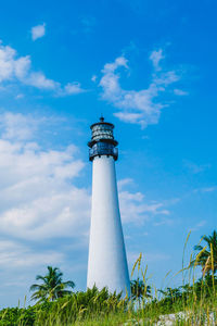 Low angle view of lighthouse by building against sky