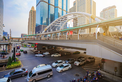 Cars on road by modern buildings in city