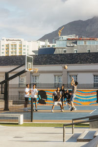 People on buildings in city against sky