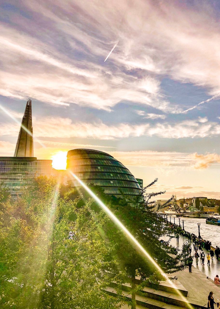 SUN SHINING THROUGH BUILDINGS IN CITY