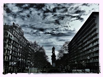 Low angle view of buildings against cloudy sky