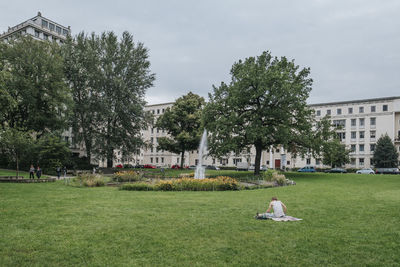 Trees and plants on field against buildings