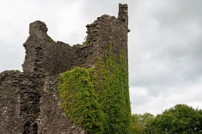 Low angle view of old ruin building against cloudy sky