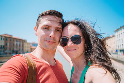 Portrait of young woman wearing sunglasses against sky