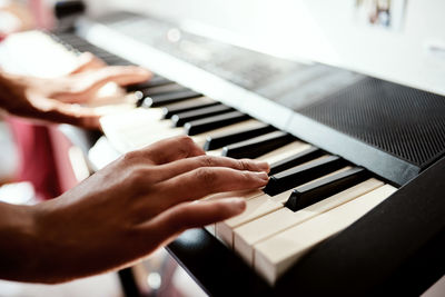 Cropped hands of woman playing piano