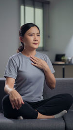 Portrait of young woman sitting at home