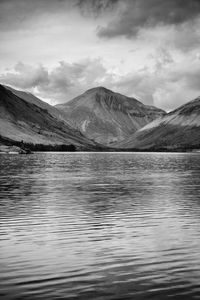 Scenic view of lake by mountains against sky