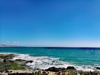 Scenic view of sea against clear blue sky