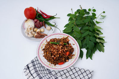 High angle view of fruits in bowl against white background