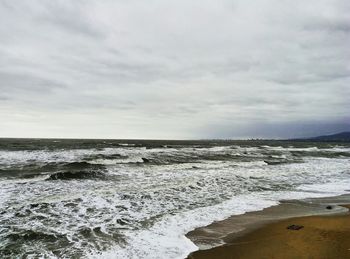 Scenic view of sea against cloudy sky