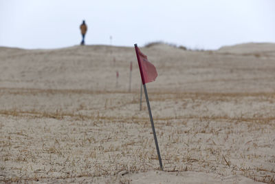 Damaged red flag on arid landscape
