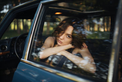 Portrait of woman sitting in car window