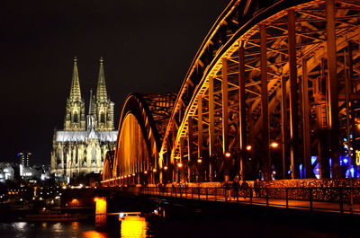 Illuminated hohenzollern bridge over rhine river with cologne cathedral