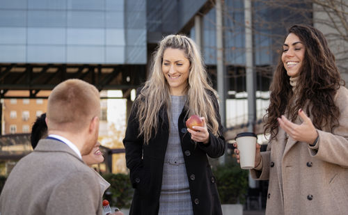 Portrait of young woman standing in city