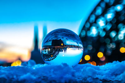 Close-up of crystal ball against blue sky