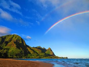 Scenic view of rainbow over sea against sky