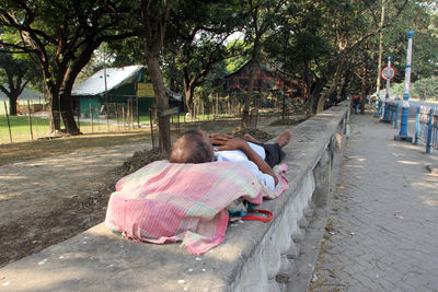 Rear view of a girl sitting on footpath