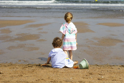 Siblings playing on the beach, the blonde older sister and the dark-haired little brother