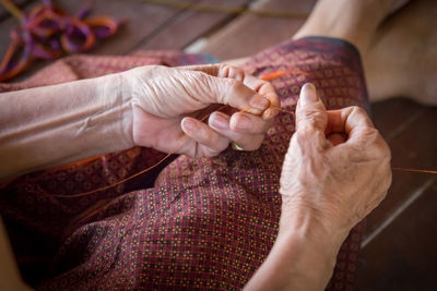 Midsection of woman holding thread