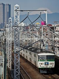 Train on railroad tracks in city against sky