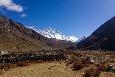 Scenic view of snowcapped mountains against blue sky