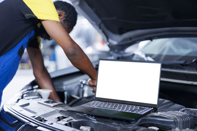 Midsection of man using laptop