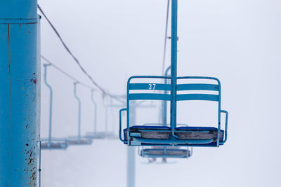 Low angle view of ski lift over snow covered field