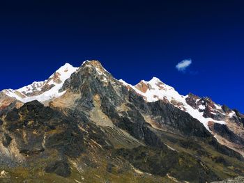 Scenic view of snowcapped mountains against blue sky