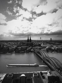 Bridge over river against cloudy sky