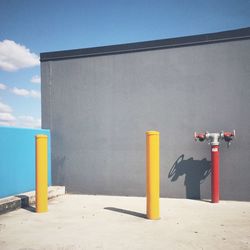 Yellow flag on concrete wall against blue sky