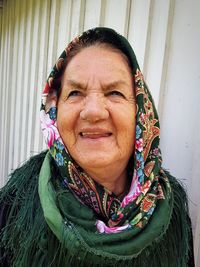 Close-up of senior woman wearing headscarf against wall