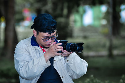 Young man photographing with camera
