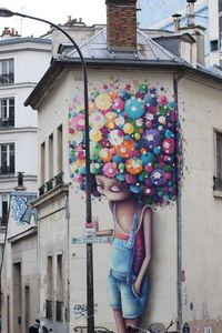 Woman standing against multi colored building