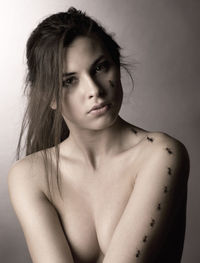 Portrait of seductive topless woman with ants over gray background