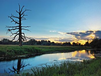 Scenic view of lake against sky at sunset