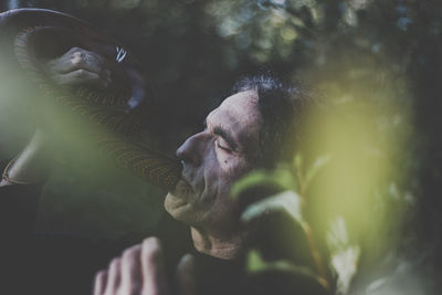 Man playing musical instrument while standing in forest