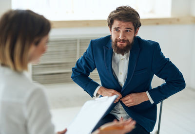 Side view of man using digital tablet while standing in office