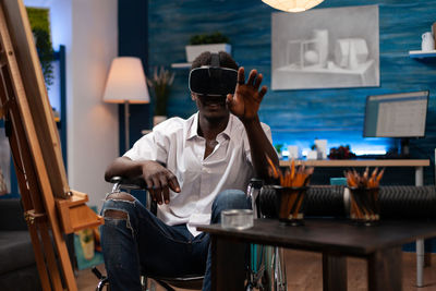 Side view of man using mobile phone while sitting in cafe