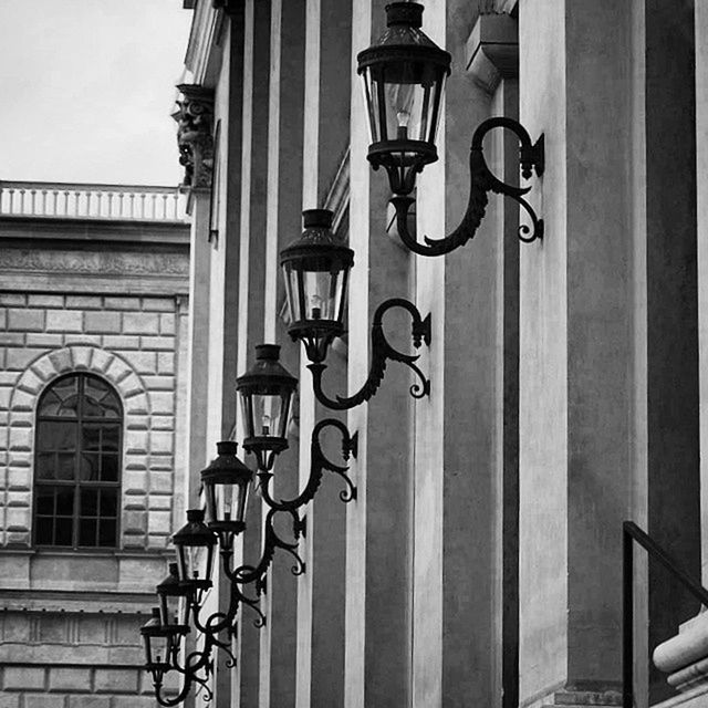 architecture, built structure, building exterior, railing, window, metal, balcony, building, low angle view, residential structure, day, hanging, residential building, no people, house, in a row, sunlight, outdoors, city, lighting equipment