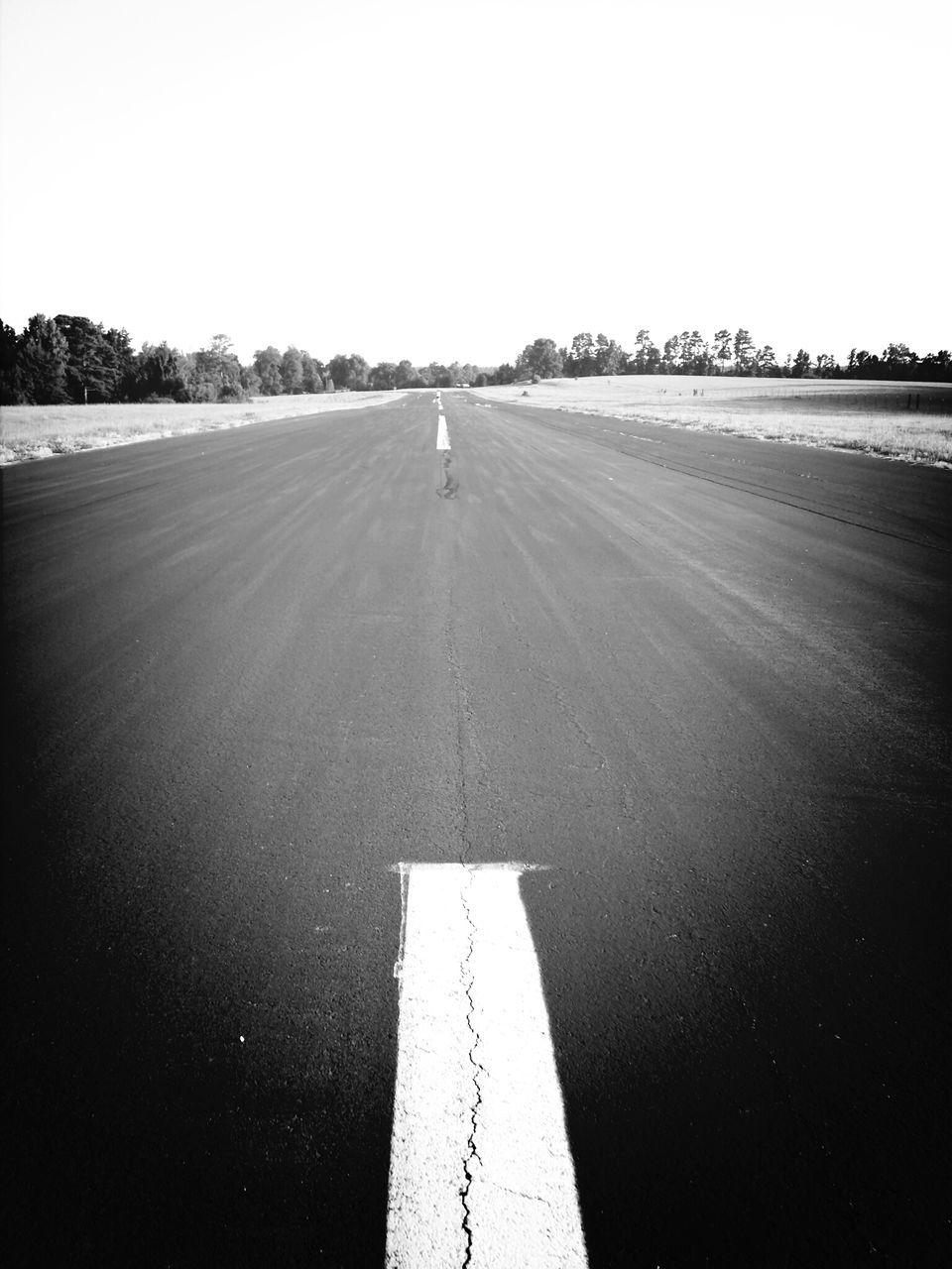 road marking, the way forward, transportation, road, clear sky, asphalt, copy space, diminishing perspective, vanishing point, street, empty, outdoors, sky, day, surface level, long, no people, empty road, tranquility, nature