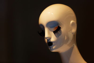 Close-up of mannequin against black background