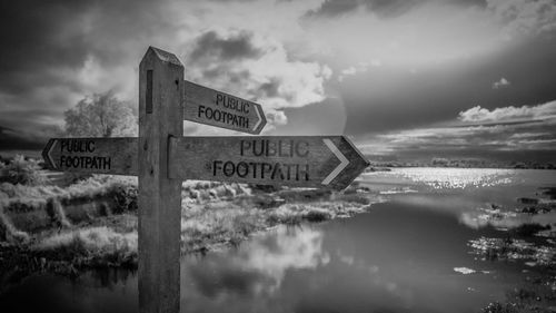 Close-up of road sign against sky