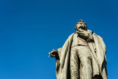 Low angle view of statue against clear blue sky