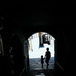 Rear view of silhouette people standing in tunnel