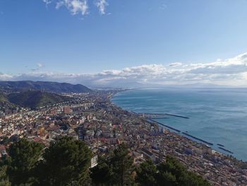 High angle view of townscape by sea against sky